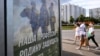 RUSSIA -- People walk past a poster promoting contract army service and reading "Our job, defending the homeland" in Moscow on September 4, 2023.