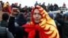 A demonstrator wearing the national flag in Bishkek gestures during an October 6, 2020 protest against the results of Kyrgyzstan's parliamentary election.