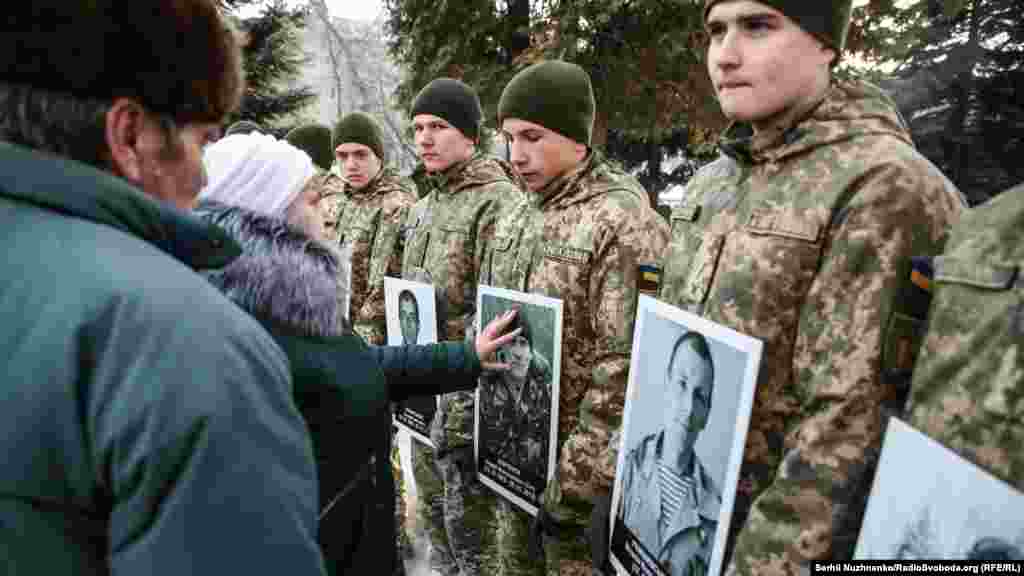 Женщина прикасается к портрету погибшего "киборга"