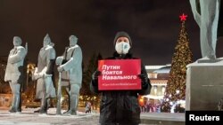 In Novosibirsk ahead of unauthorized January 23, 2021 demonstrations for opposition leader Aleksei Navalny's release from jail, a lone protester holds a sign that reads "Putin is afraid of Navalny." 
