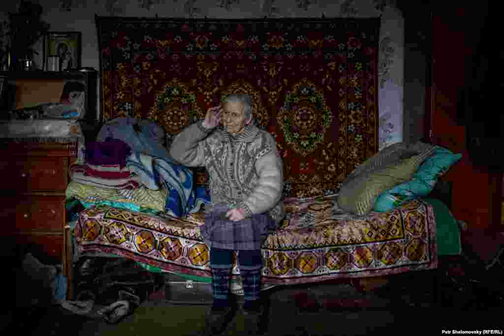 Раиса Казакова внутри своего дома, где она живет с 9 другими пенсионерами. Все они потеряли свои дома при обстрелах. 