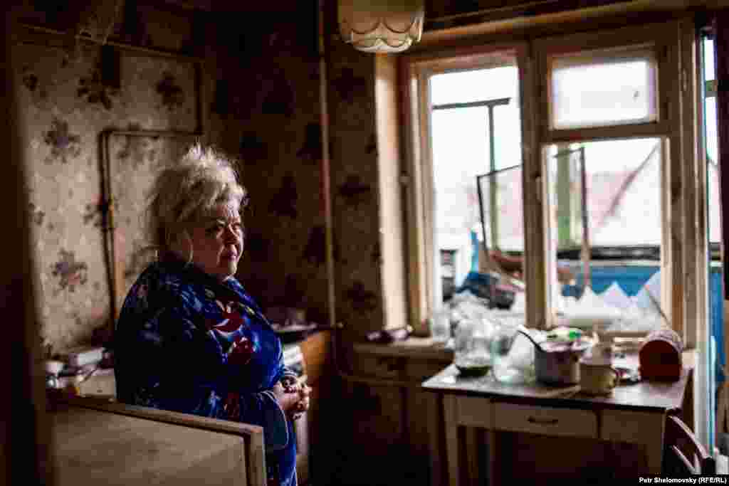 Вера показывает разрушения, причиненные ее дому 