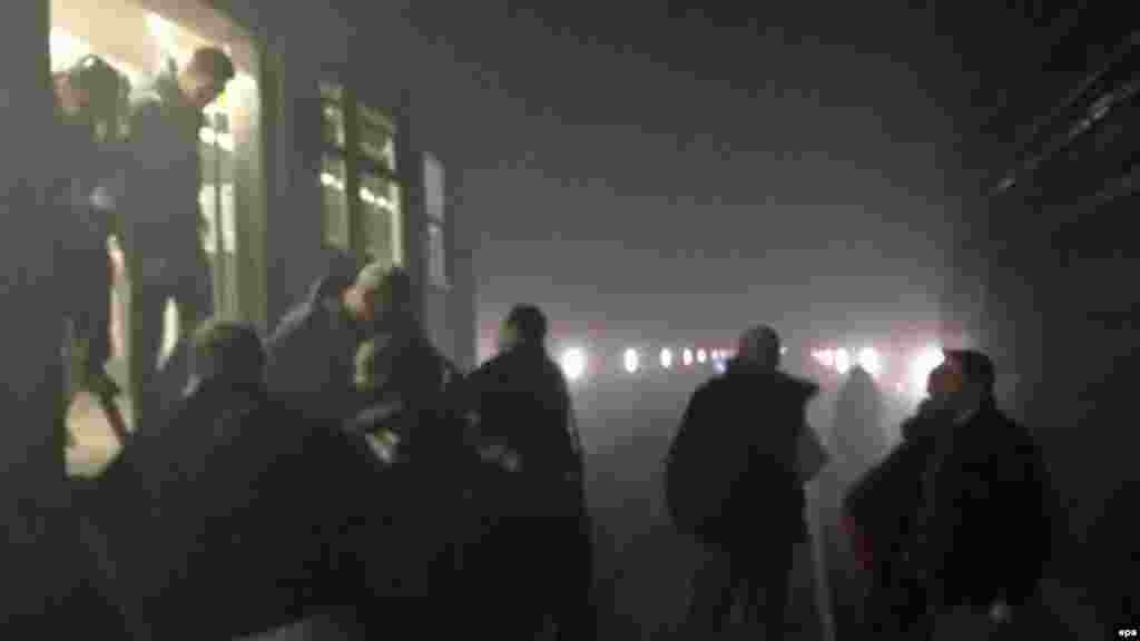 Пассажиры выходят из поезда метро в туннель между станциями Арс-Луа и Маельбек после взрыва на станции Маельбек в центре Брюсселя