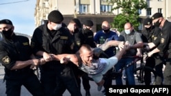 Belarus' riot police officers detain an opposition supporter during a gathering to support candidates seeking to challenge President Alyaksandr Lukashenka.
