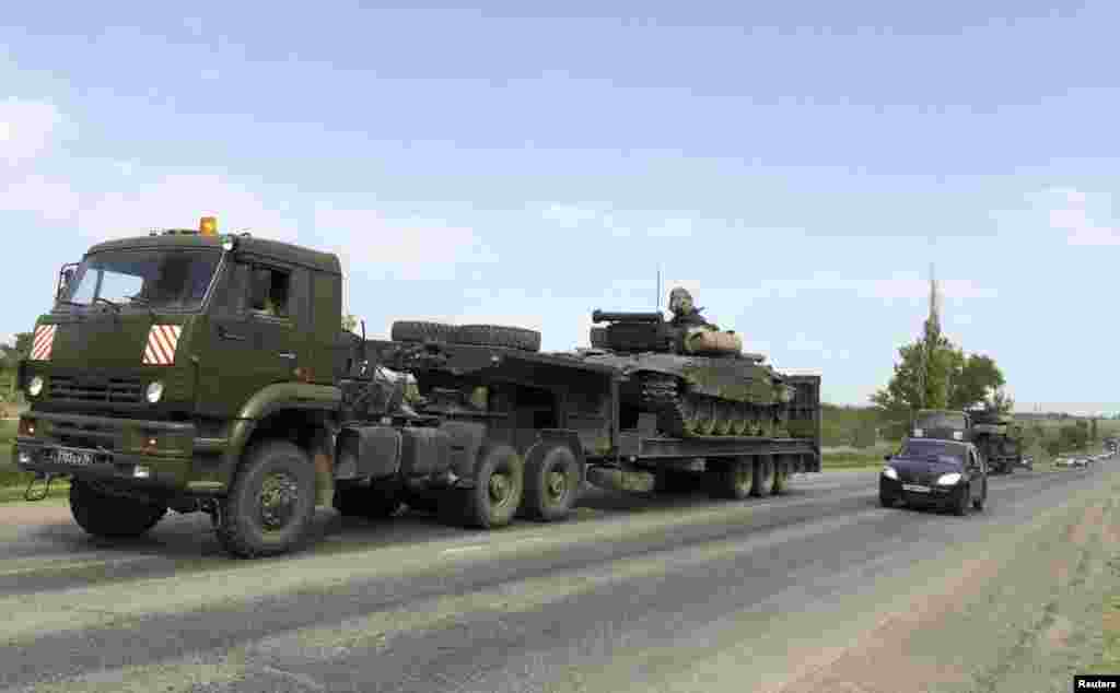 Грузовики перевозят танки по трассе на российско-украинской границе. За три месяца количество техники на полигоне Кузьминский в Ростовской области увеличилось примерно в три раза