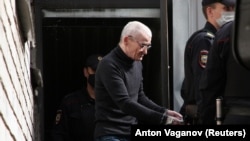  Russian historian Yury Dmitriyev, who was charged with sexually abusing his adopted daughter, is escorted by police officers after a court hearing in Petrozavodsk, Russia on July 22, 2020.