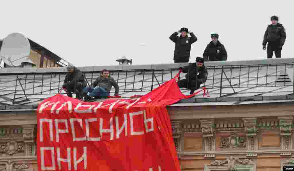 Полиция пытается снять с крыши дома в Санкт-Петербурге активистов "Другой России", которые вывесили растяжку "Ильич, проснись. Они ох*ели" 4 ноября. Задержали 23 человека