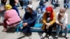 Bishkek residents wait for their turn to receive medical care near a day hospital in the Kyrgyz capital on July 6, 2020.