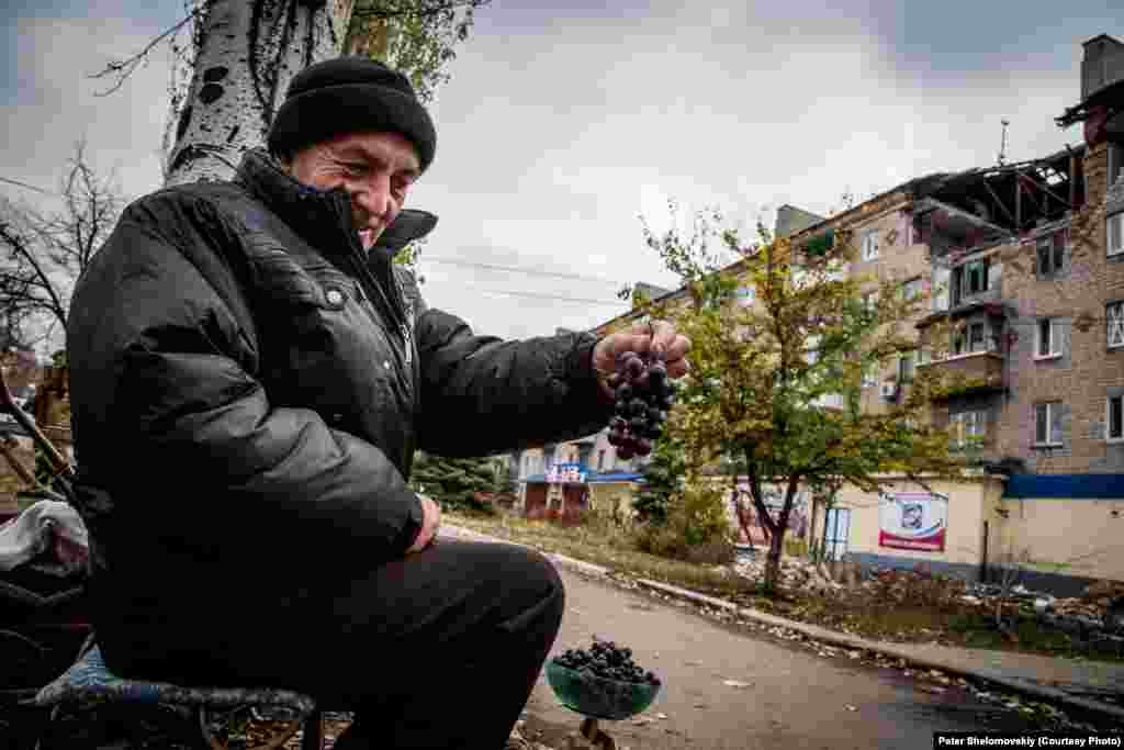 Житель Горловки - Николай - продает виноград, который он выращивает в своем саду. Население возврашается в свои дома, но найти работу очень сложно. Горловка. Украина. Октябрь 2014